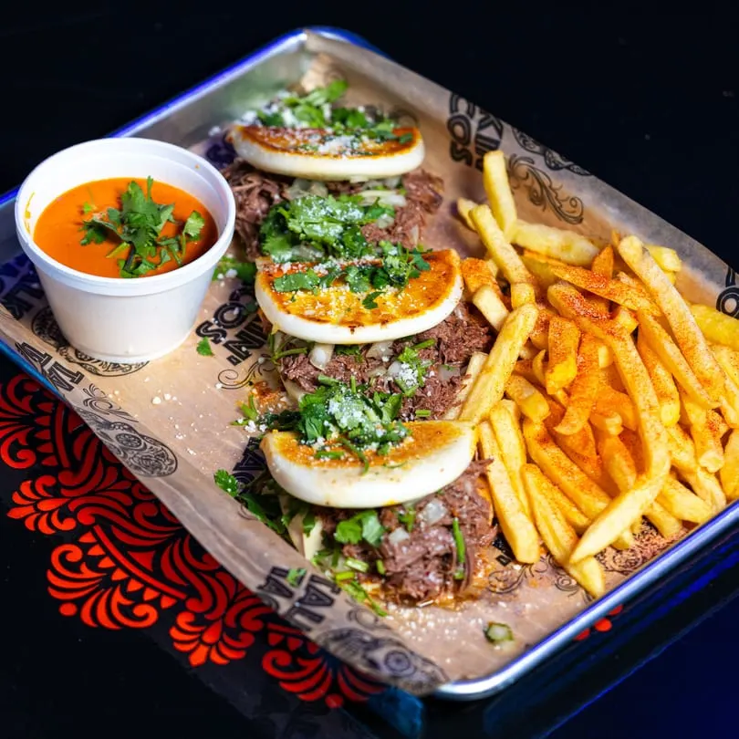 Four Talkin' Tacos birria tacos with a side of fries and a cup of consommé.